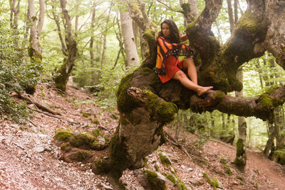 Woman sitting on rock in forest