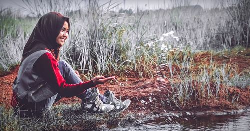 Side view of woman sitting in water