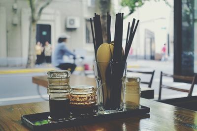 Sauce and drinking straws in glass on restaurant table
