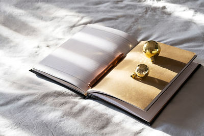 Open notebook, pen and sparkling christmas balls on bed. new year goals. 