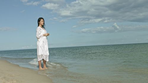 Full length of man standing on beach against sky