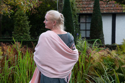 Young beautiful woman in a long dress with a floral print and a pink shawl