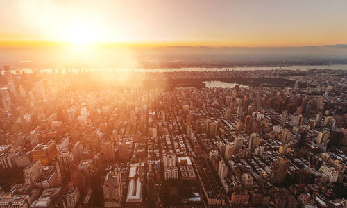 High angle view of illuminated cityscape against sky during sunset