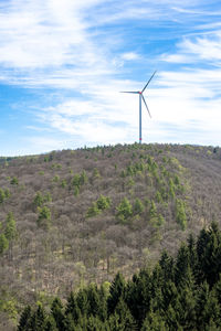 Windmill on landscape against sky