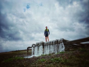 Rear view of man standing on land against sky