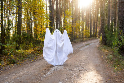 Rear view of woman standing in forest