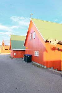 Houses by road against sky in city