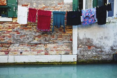 Clothesline against brick wall house over canal