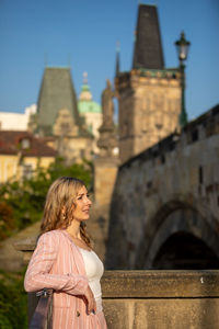 Smiling woman standing against castle