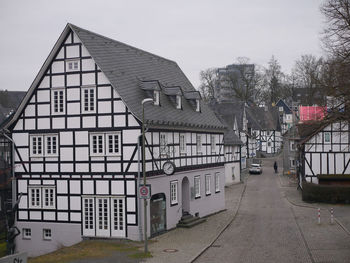 Street amidst houses and buildings against sky