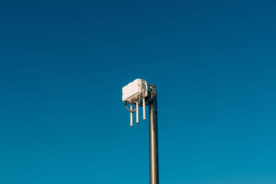 Low angle view of floodlight against blue sky