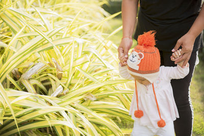 Midsection of woman holding toy while standing on field