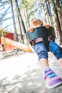 Girl sitting on swing at playground