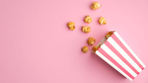 High angle view of pink cake against colored background