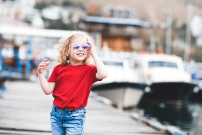 Happy girl with sunglasses walking on jetty