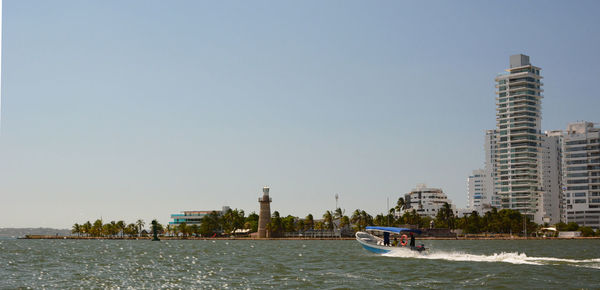 Boats in sea against clear sky