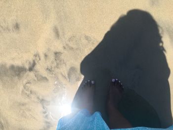 Low section of woman on sand