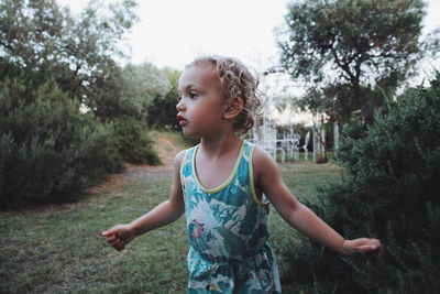 Girl looking away while standing on land