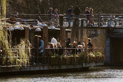 People on boat and bridge over river