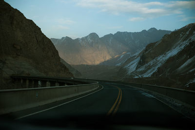 Road amidst mountains against sky