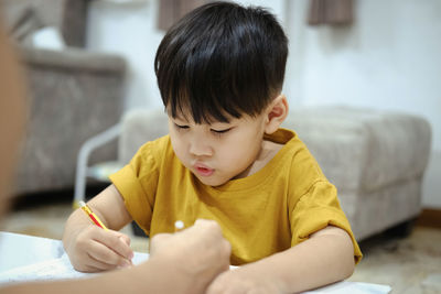 Midsection of boy holding table at home