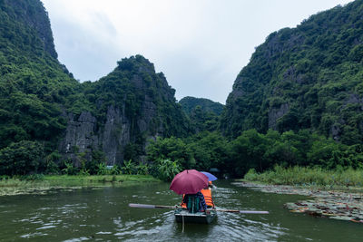 Rear view of man with umbrella in lake