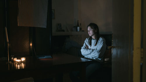 Young woman watching video over laptop on table at home