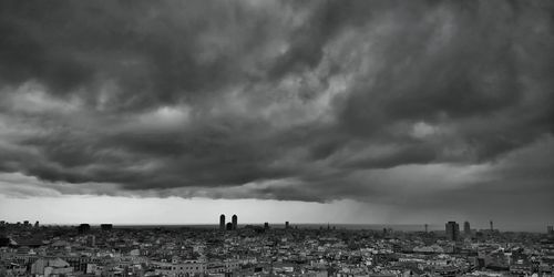 View of cityscape against cloudy sky