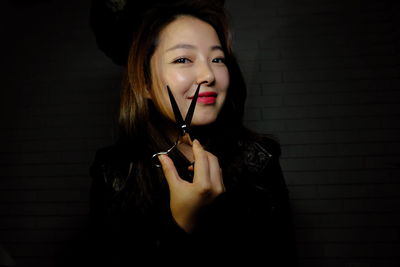 Portrait of young woman holding scissor