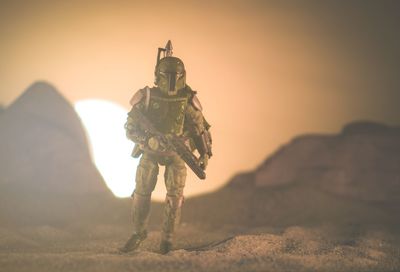 Low angle view of man standing in desert during sunset
