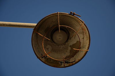 Low angle view of old rusty against blue sky