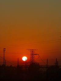 Low angle view of silhouette electricity pylon against romantic sky