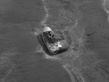 High angle view of abandoned canvas boot at sandy beach