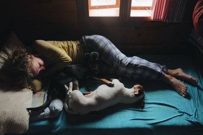 Woman with dogs relaxing on bed