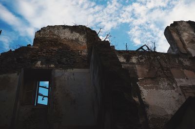 Low angle view of building against cloudy sky