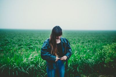 Woman standing on field against clear sky