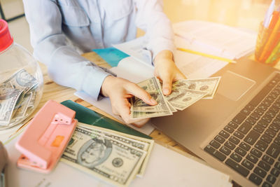 Midsection of man using laptop on table