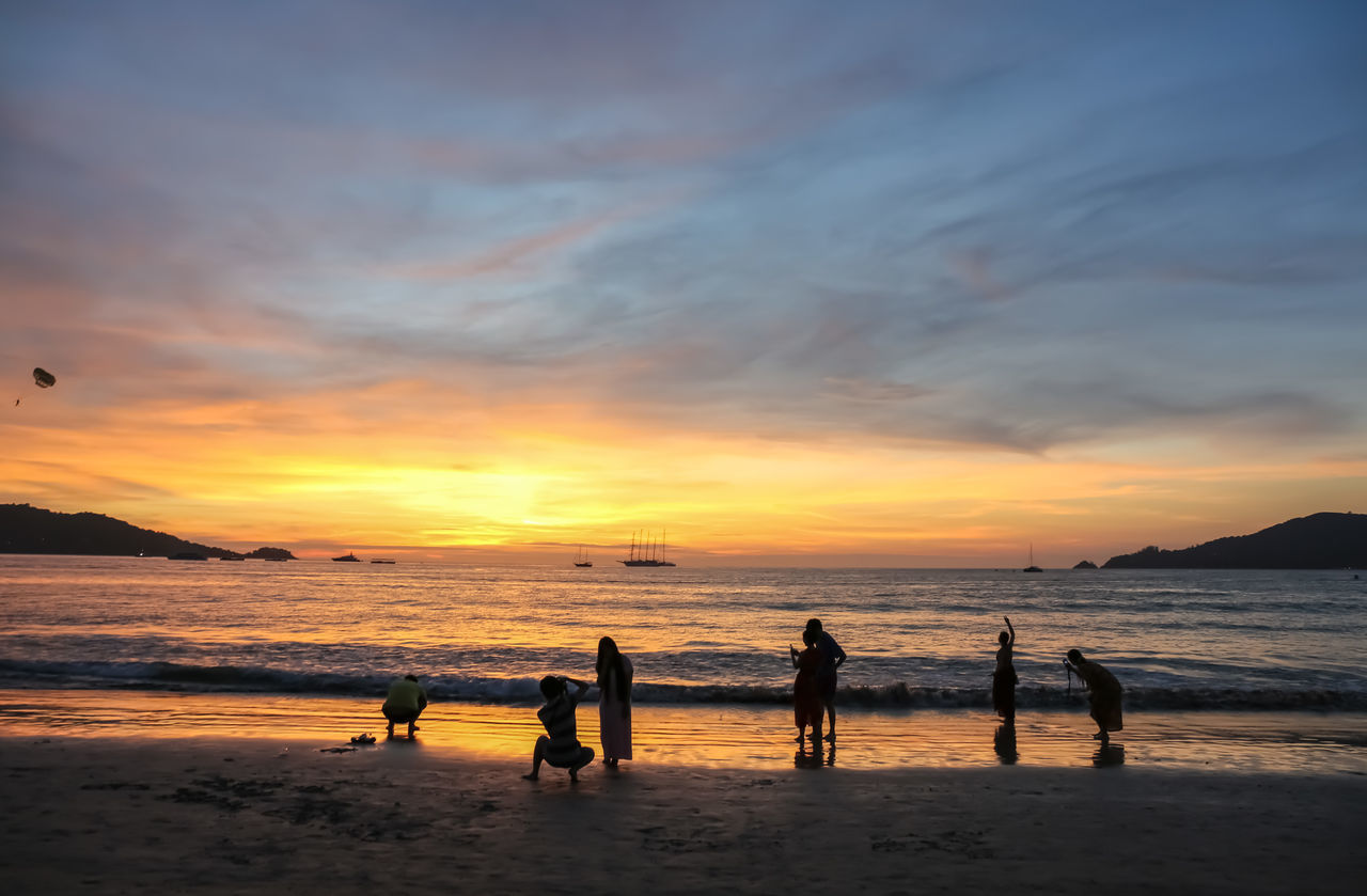 sunset, beach, sea, water, nature, beauty in nature, sky, scenics, silhouette, leisure activity, sand, outdoors, real people, lifestyles, enjoyment, vacations, horizon over water, men, sport, wave, beach volleyball, day, people