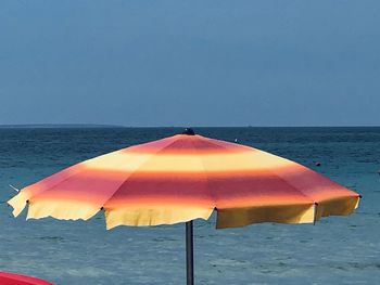 Umbrella on beach against clear sky