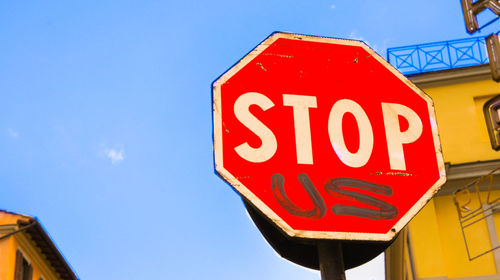 Low angle view of sign board against sky