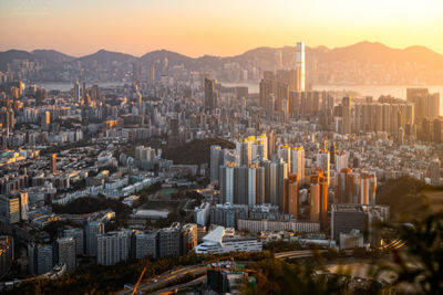 Aerial view of buildings in city against sky during sunset