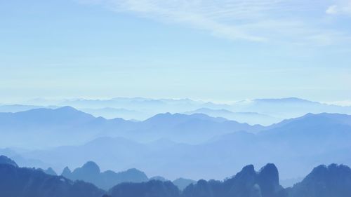 Scenic view of mountains against blue sky