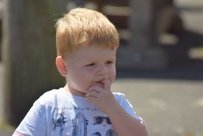 Close-up of cute boy biting nail