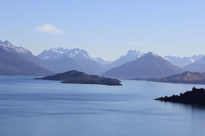 Scenic view of sea and mountains against sky