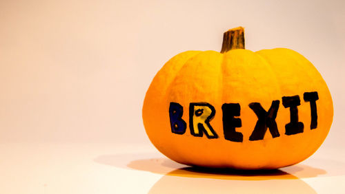 Close-up of pumpkin on table against white background