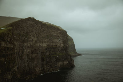 Rock formations by sea against sky