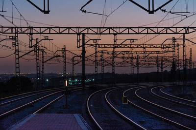 Railway tracks against clear sky during sunset