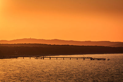 Scenic view of lake against orange sky