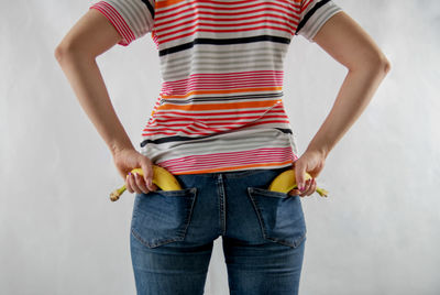 Midsection of woman standing against white background