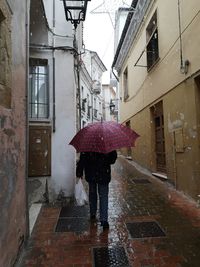 Rear view of man on wet street during rainy season